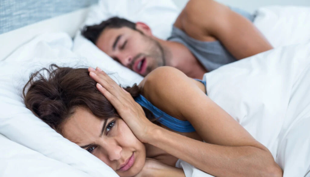 man snoring wife unable to sleep and covering ears